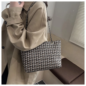 Detail of checkered tote bag showing tweed texture and elegant metal chain strap