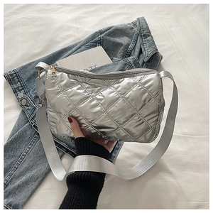Detailed view of silver quilted crossbody bag featuring rhombic stitching and wide strap