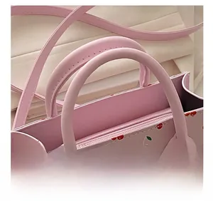 Dettaglio della borsa rosa in PU con motivi a ciliegia e comodi doppi manici