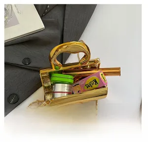 Detailed interior view of golden metal cylinder bag showing capacity for lipstick and makeup