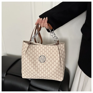 Détail du sac cabas avec imprimé monogramme M marron et logo en métal argenté