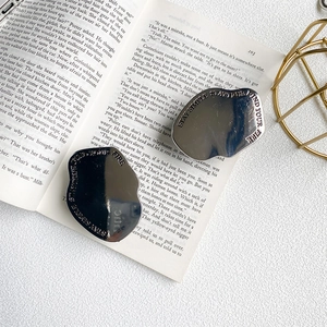 Detail of silver plated geometric phone socket with Stay True engraving on open book