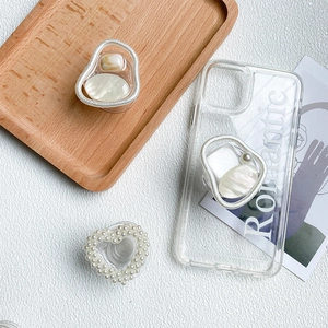 Close-up of pearl heart and marble griptok on a transparent phone case