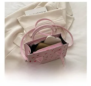 Vista interna della borsa rosa con ciliegie che mostra lo spazio per telefono e portafoglio