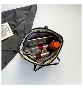 Top view of spacious interior of black tote bag showing storage for tablet and essentials