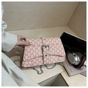 Detail of pink monogram crossbody bag with chunky silver chain and letter M print