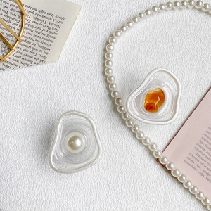 Detail showing irregular resin phone grip with embedded pearl and amber stone