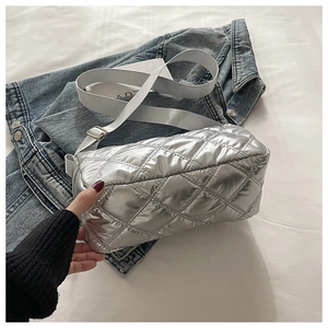 Detail of silver quilted tote bag with adjustable strap shown in a casual lifestyle setting