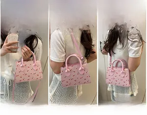 Tre modi di indossare la borsa rosa con ciliegie: a mano, a spalla e a tracolla regolabile