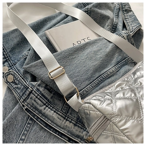 Close-up of silver quilted cylinder bag with rhombic stitching and metal finish