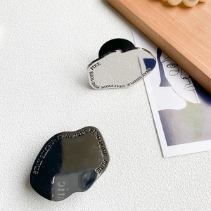Macro detail of silver mirror metal phone grip with engraved motivational typography