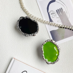 Artistic irregular metal phone grips in glossy black and vibrant green with silver texture