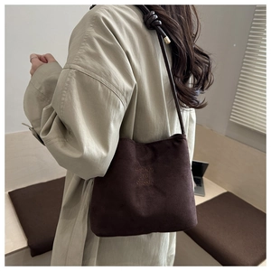 Detail view of dark brown suede tote bag with fashion and classic embroidery text