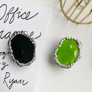 Detail of silver irregular metal phone grips with black and green lava texture enamel