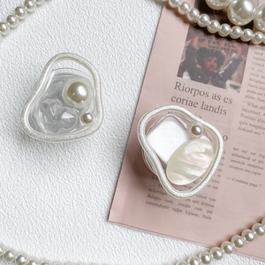Detail of irregular silver phone sockets with pearls and iridescent marble shell inlay