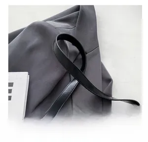 Detail of glossy black leather shoulder strap with fine stitching on a French style bag
