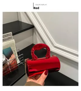 Detail of red metallic mini handbag with glossy finish and fine gold chain strap