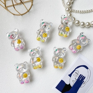 Flat lay of resin bear phone stands filled with colorful sequins and floral icons