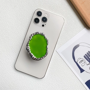 Irregular green gemstone metal phone grip holder on smartphone with silver texture