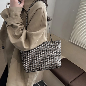 Plaid tweed large tote bag with gold chain strap worn with a stylish trench coat