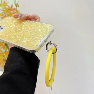 Detail of yellow glitter phone case featuring a matching silicone ring wristband and silver clasp