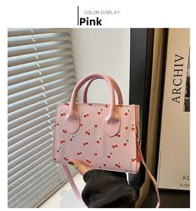 Detail of pink PU leather crossbody bag with sweet cherry prints and adjustable strap