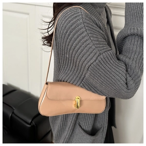 Detailansicht einer apricotfarbenen Baguette-Tasche mit edlem Goldverschluss als Bag