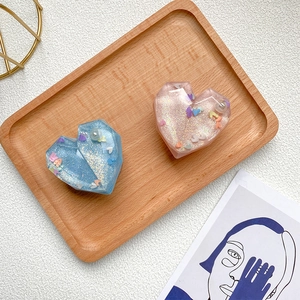 Macro detail of heart-shaped resin phone grips with glitter and faux pearl inlays