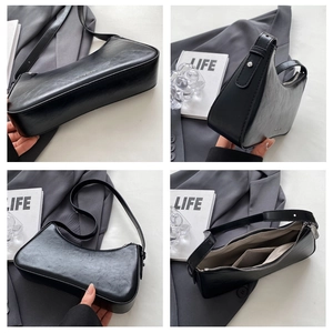 Detail view of black vintage underarm bag featuring silver zipper and interior pocket