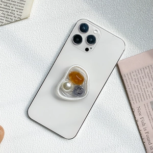 Chic phone socket with large white pearl, amber stone, and flower on marble surface