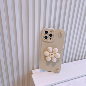 Detail of cream iPhone case featuring a large white 3D flower and gold metal lanyard rings