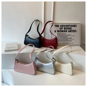 Detail of five assorted hobo bags on display stands featuring sleek PU leather and metal zips