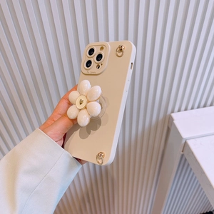 Detail of iPhone case with 3D white flower grip and golden rings in beige finish