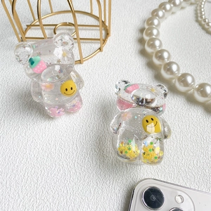 Close-up of cute bear-shaped resin phone grips with glitter, flowers and smiley face