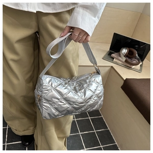 Detailed close-up of a silver quilted shoulder bag featuring metallic finish and wide strap