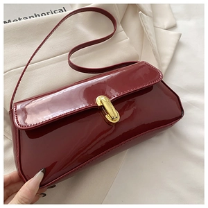 Details von weinrotem Lackleder mit Hochglanz-Effekt und eleganter Metallschnalle