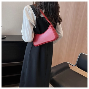 Detail of red leather hobo bag showing crescent shape and smooth texture on shoulder