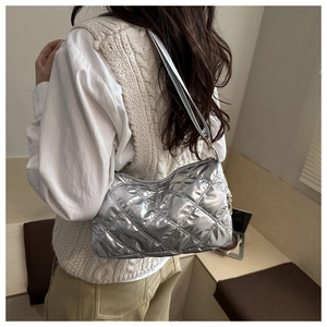 Quilted silver metallic shoulder bag with diamond stitching shown on model back