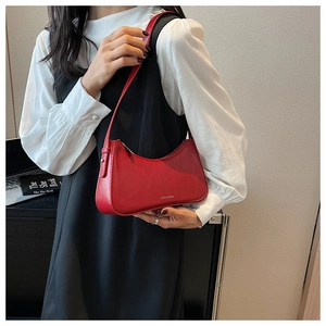 Detail of red matte leather hobo bag with a zipper closure and thin shoulder strap