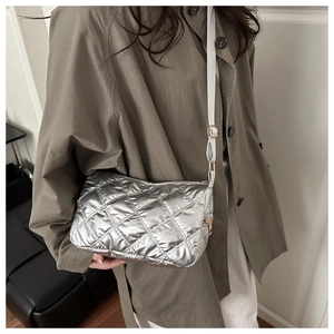 Detailed view of silver quilted crossbody bag with adjustable strap and zipper closure