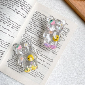 Close-up of bear-shaped phone holders with embedded strawberry and daisy decorations