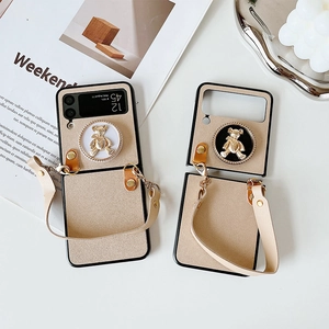 Beige matte Samsung Z Flip case with gold bear relief and leather hand strap