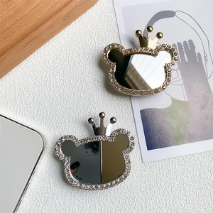Macro detail of gold and silver bear phone grips with crown design and rhinestones