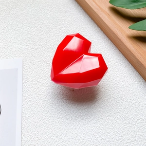 Macro detail of red 3D geometric heart phone grip with high gloss faceted surfaces