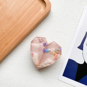 Detailed close-up of pink heart resin popsocket with glitter, sequins and pearl inlay