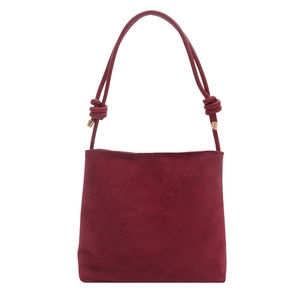 Classic burgundy suede bucket bag with stylish knotted strap and embossed fashion text
