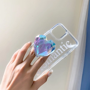 Detail of hand holding clear phone case with purple 3D heart grip and Romantic text