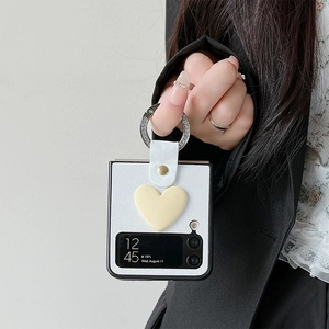 Detail of white leather folding phone case with yellow 3D heart charm and ring buckle