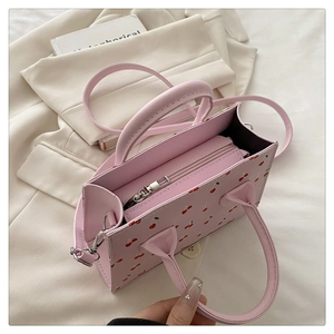 Vue détaillée du sac cabas rose à motif cerise avec compartiment zippé et bandoulière