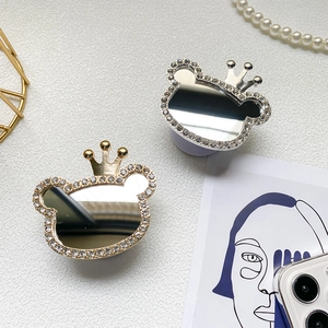 Close-up of gold and silver bear crown phone grips with rhinestones and mirrors